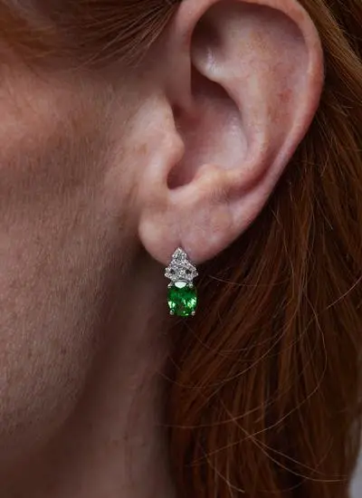 Close up shot of red haired model wearing Sterling Silver Trinity Knot Earrings with Green Cubic Zirconia